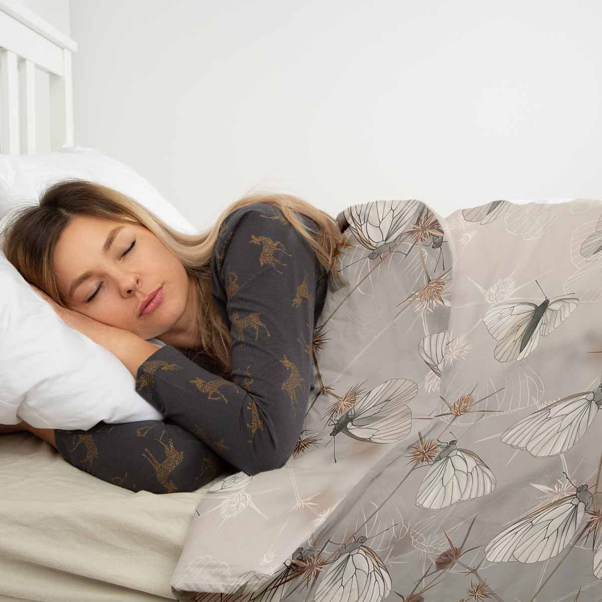 Juego de ropa de cama beige con mantas terapéuticas y polillas