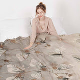 Juego de ropa de cama beige con mantas terapéuticas y polillas