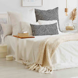 Almohada de salud gris con hojas de palma blancas