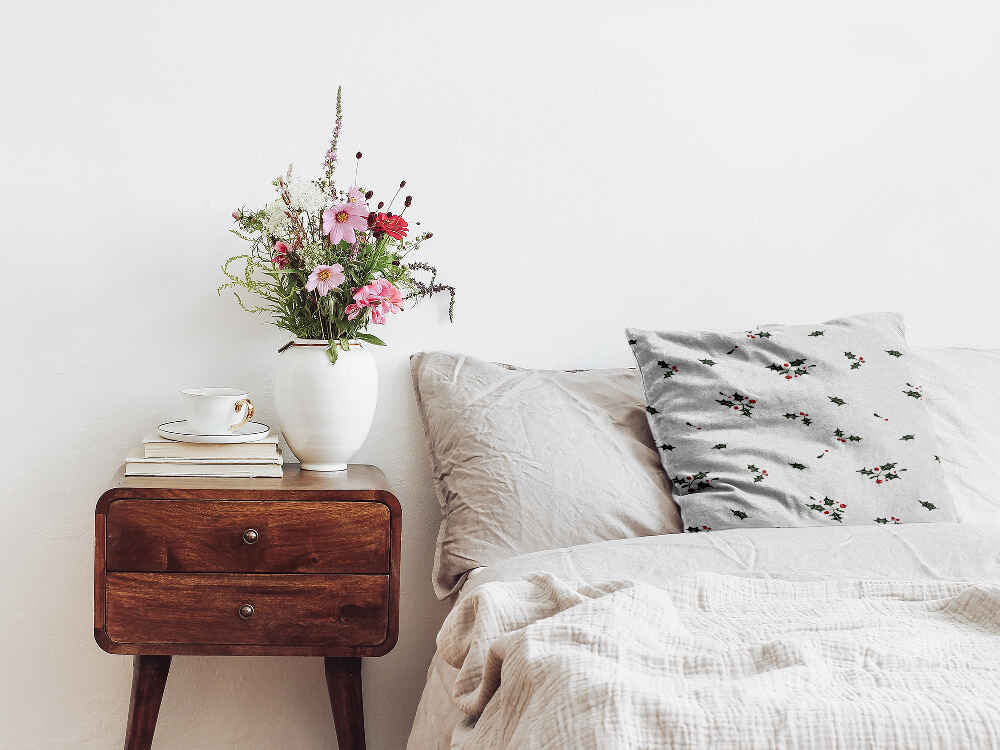 Almohada de salud blanca con ramas de muérdago